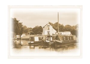 Vintage-effect landscape image of canal boats at Swarkestone Lock